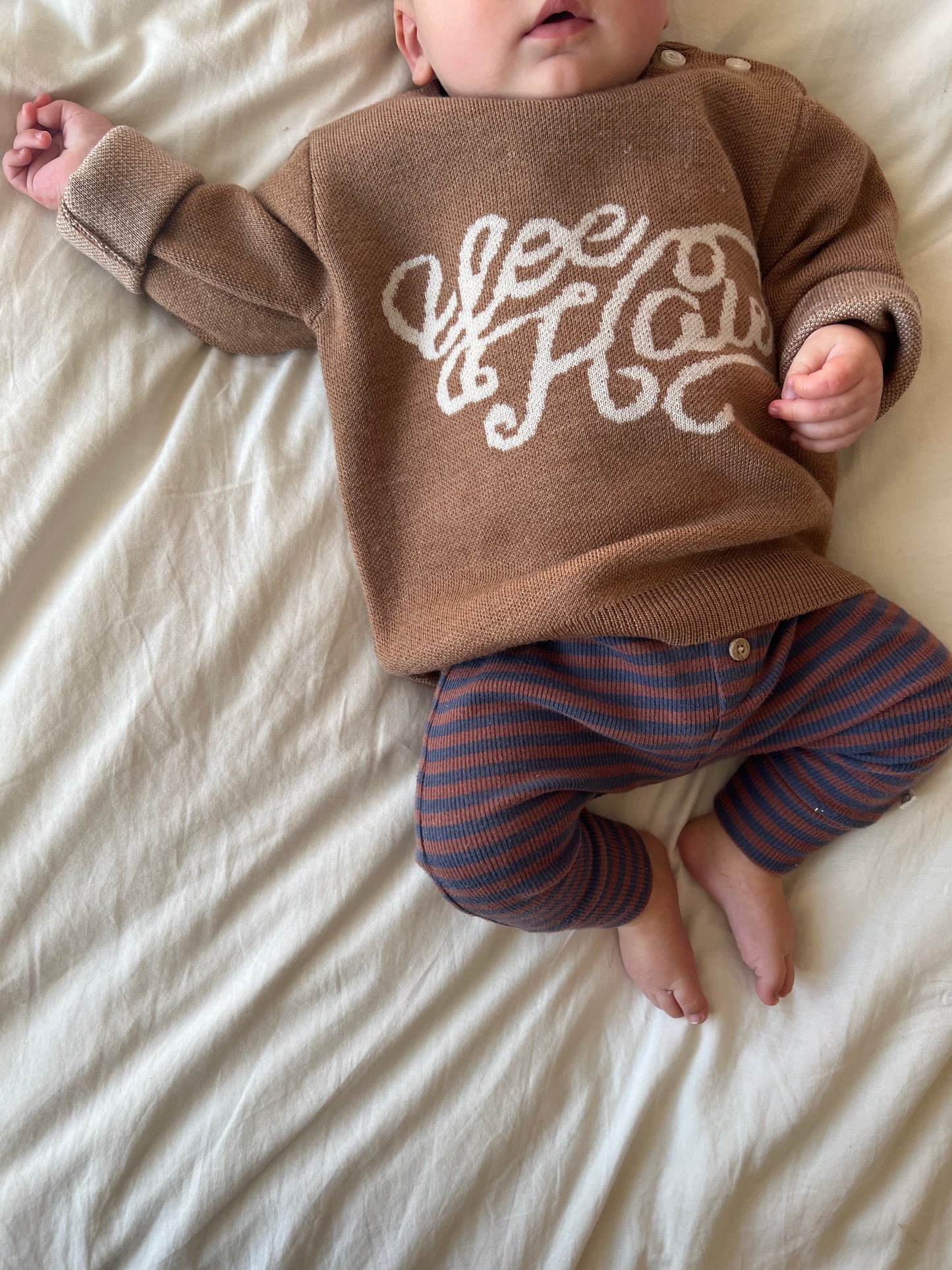 Baby wearing a brown knitted sweater with white yeehaw western theme