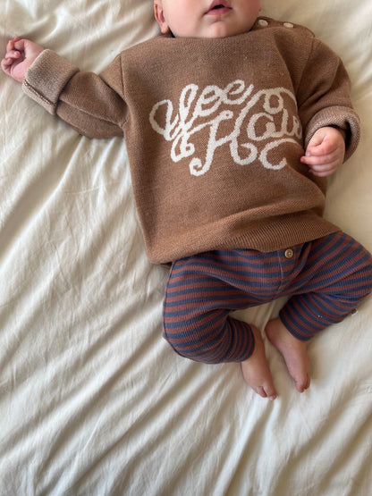 Baby wearing a brown knitted sweater with white yeehaw western theme