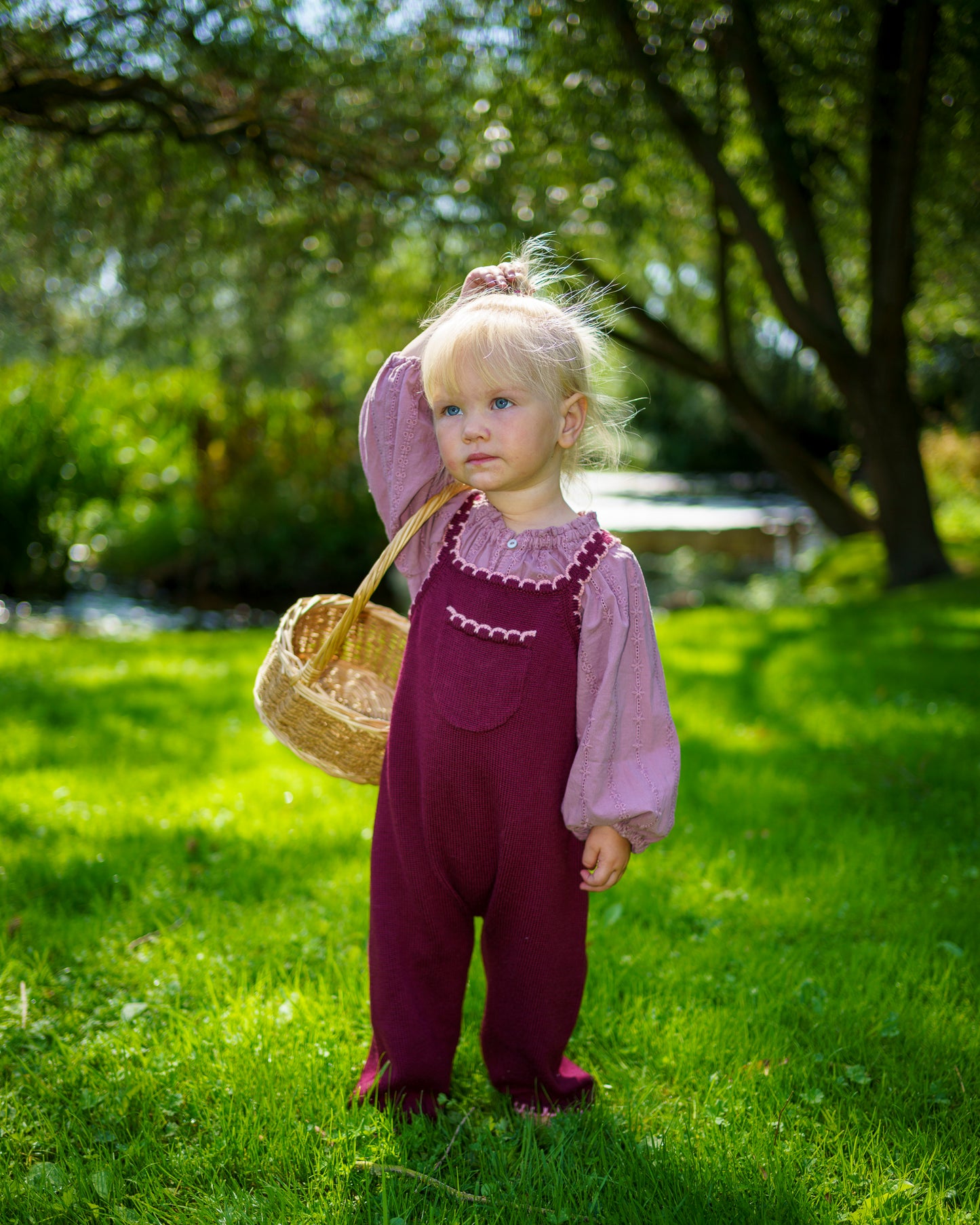 Children’s plum merino wool dungarees with adjustable straps and pink scallop detail