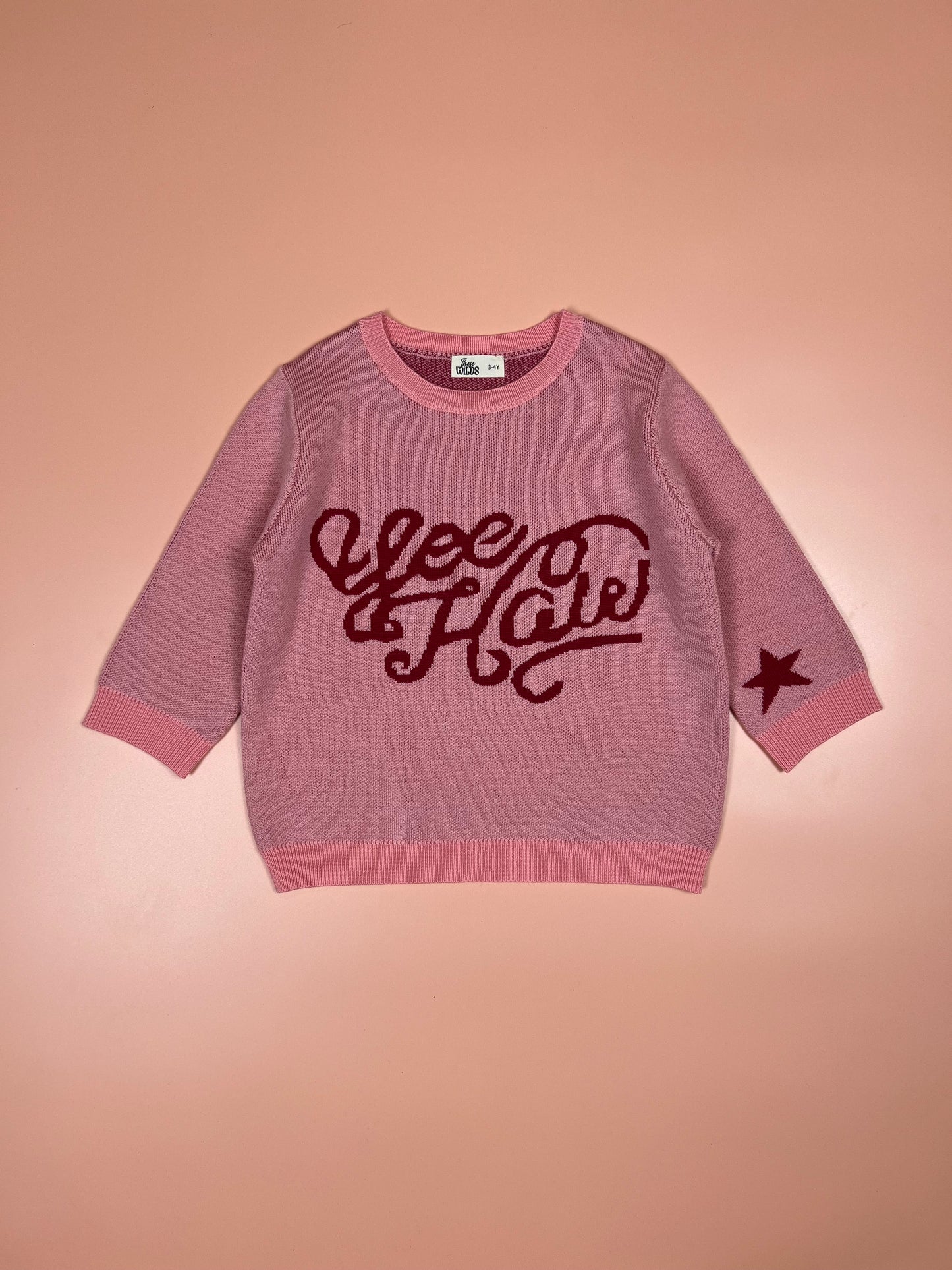 Soft pink children’s merino wool jumper featuring a cute yeehaw motif.